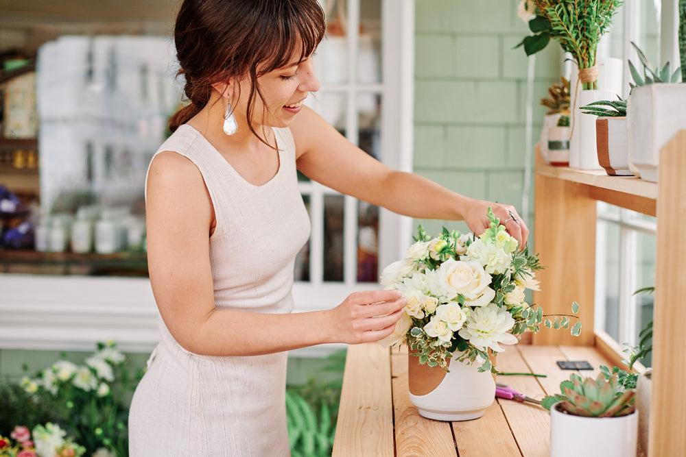 florist assembling a sympathy flower arrangement